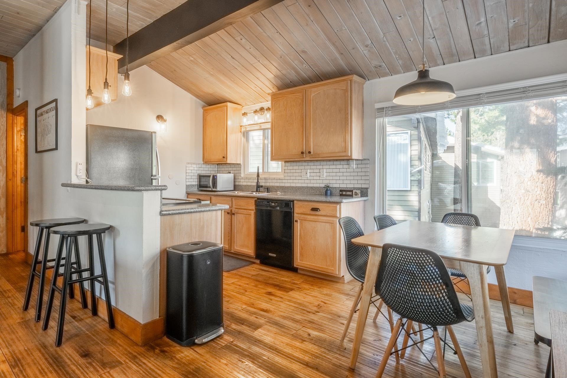 2290 Sierra Nevada Road, Unit 43 Mammoth Lakes, CA 93546 - Photo 10 of 33 a kitchen with stainless steel appliances granite countertop a stove top oven a sink dishwasher a dining table and chairs with wooden floor