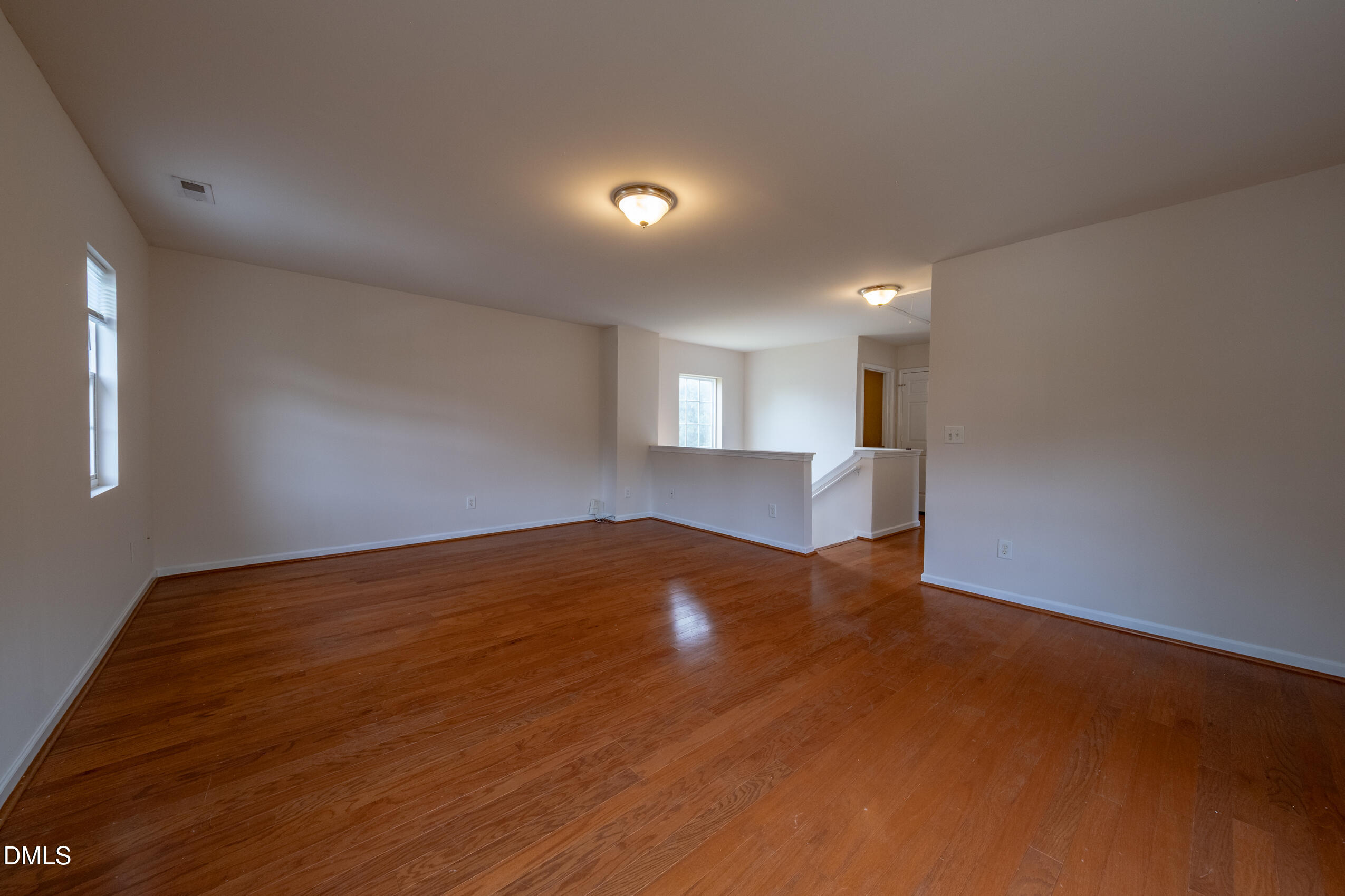 719 Obsidian Way Durham, NC 27703 - Photo 22 of 41 an empty room with wooden floor and windows