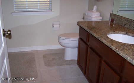 97285 Castle Ridge Drive Yulee, FL 32097 - Photo 17 of 23 a bathroom with a granite countertop sink a toilet and a mirror