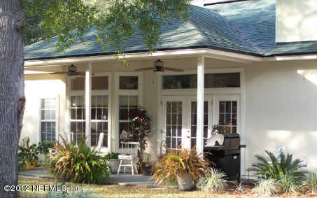 97285 Castle Ridge Drive Yulee, FL 32097 - Photo 6 of 23 a view of a house with potted plants and a table and chairs