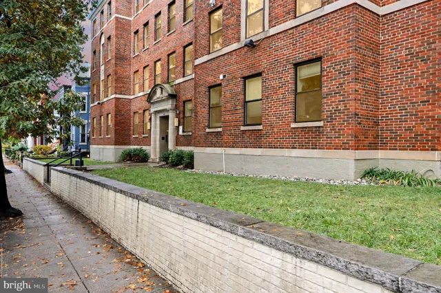 a brick building with a yard in front of it