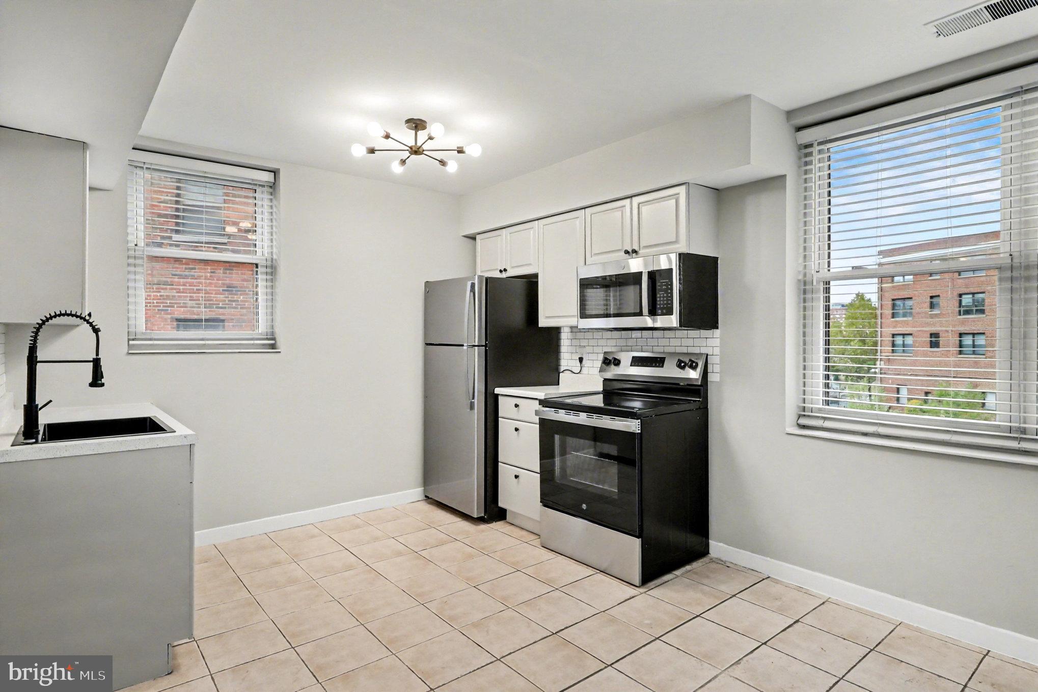 66 New York Avenue Northwest, Unit 206 Washington, DC 20001 - Photo 8 of 24 a kitchen with stainless steel appliances granite countertop a stove a sink dishwasher a refrigerator and a microwave oven