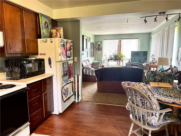 a work place with furniture a large window and wooden floor