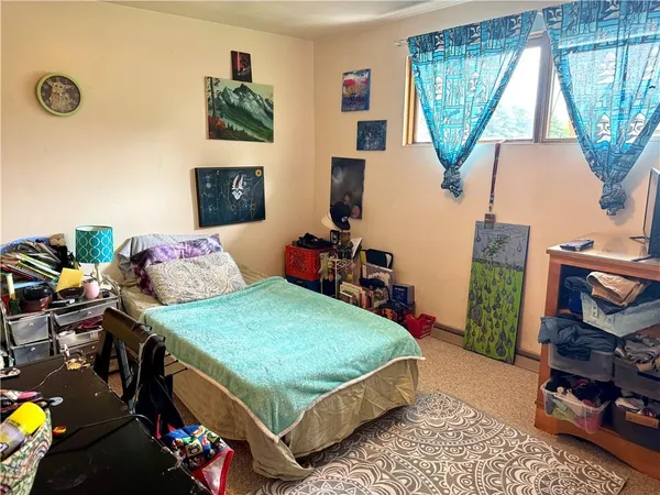 a bedroom with a bed a dresser and a window