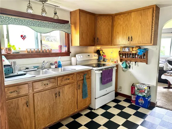a kitchen with a sink a stove cabinets and a window