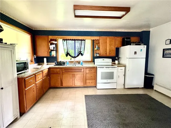 a kitchen with a refrigerator a stove top oven and a large window