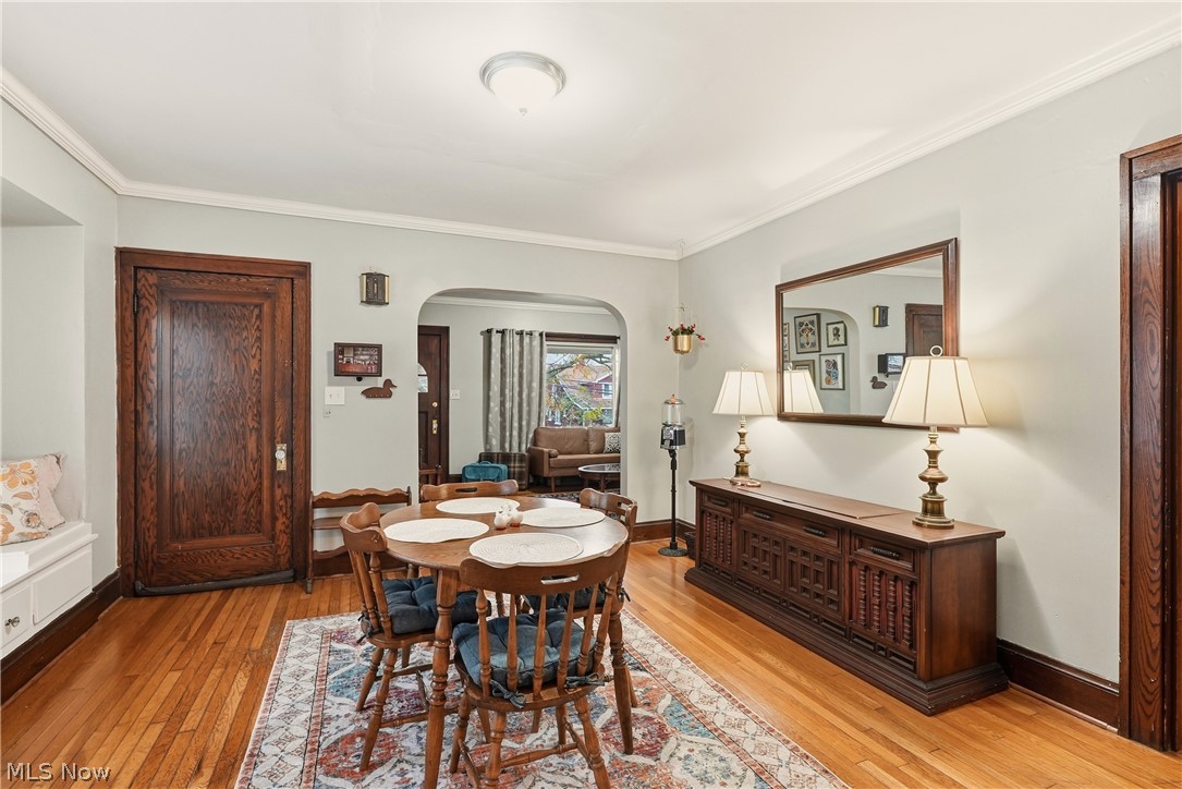 3579 Bosworth Road Cleveland, OH 44111 - Photo 12 of 39 Hardwood flooring throughout the dining area, featuring a decorative archway and dark wood trim
