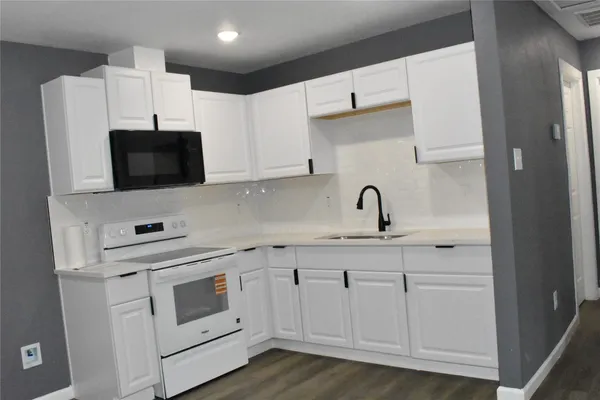 a kitchen with white cabinets and white appliances