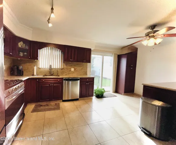 a kitchen with stainless steel appliances granite countertop a stove top oven a sink a counter space and cabinets