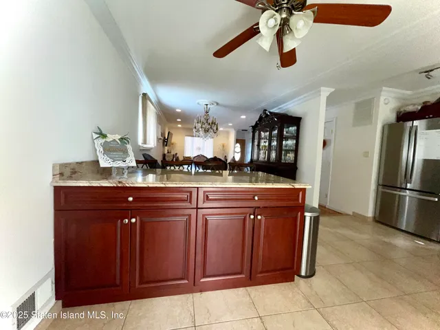 a kitchen with kitchen island a large counter top space appliances and a ceiling fan