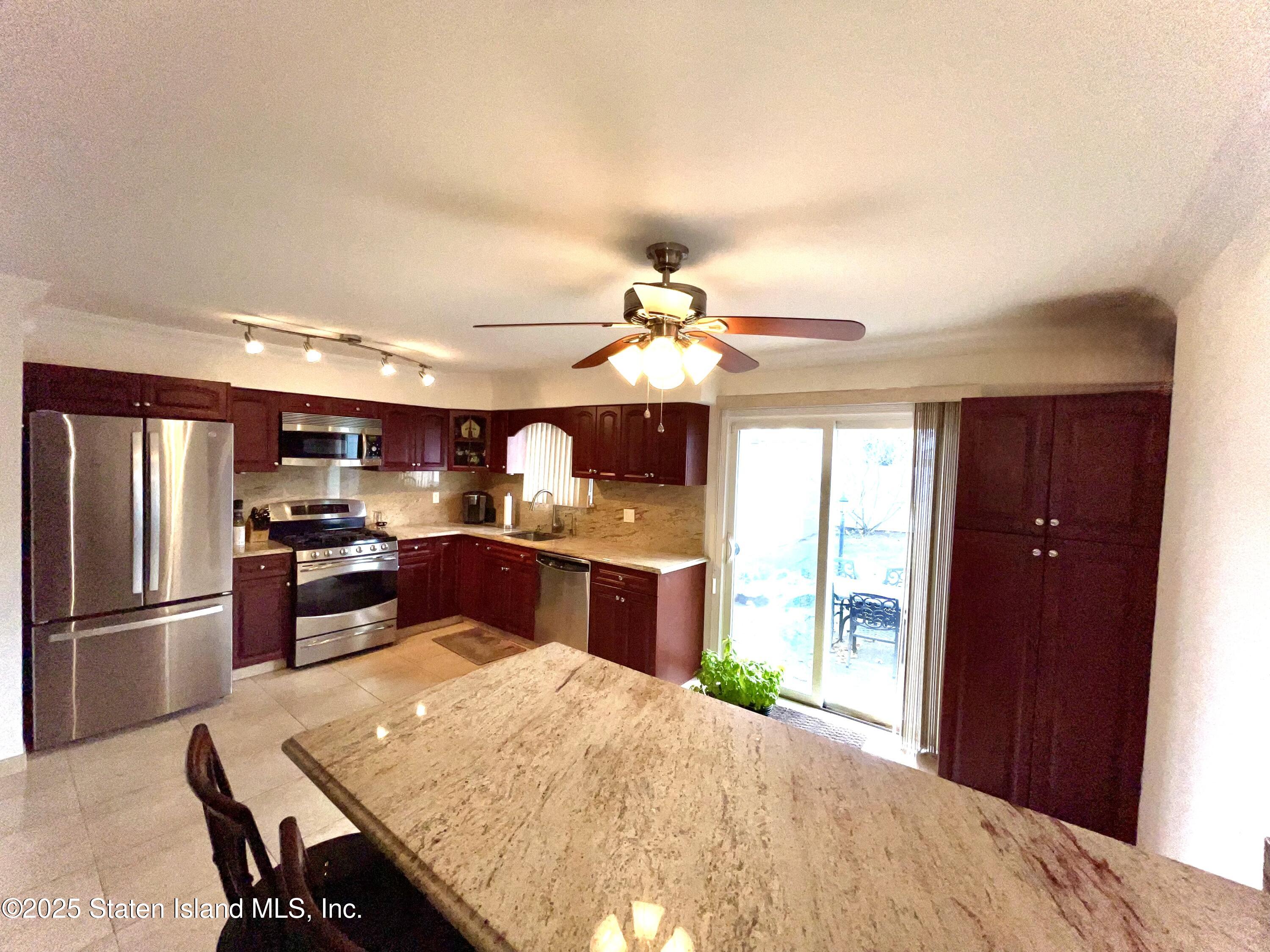 10 Token Street Staten Island, NY 10312 - Photo 14 of 39 a kitchen with kitchen island a large counter top space appliances and a ceiling fan