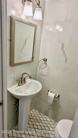 a white toilet sitting next to a white cabinet
