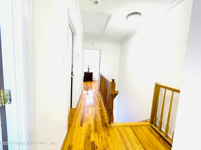 a bedroom with a bed and a lamp on dresser