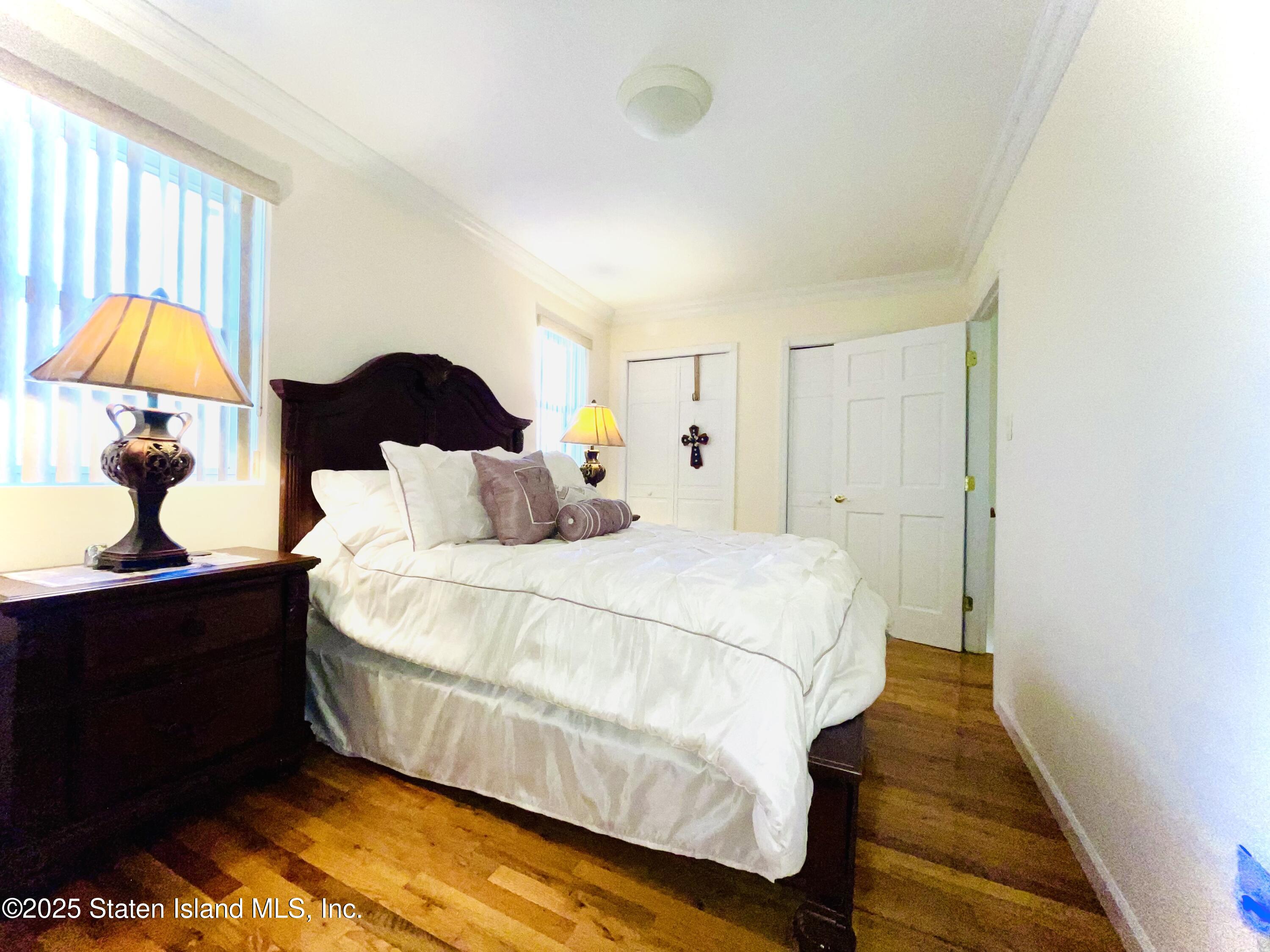 10 Token Street Staten Island, NY 10312 - Photo 25 of 39 a bedroom with a bed and a lamp on dresser