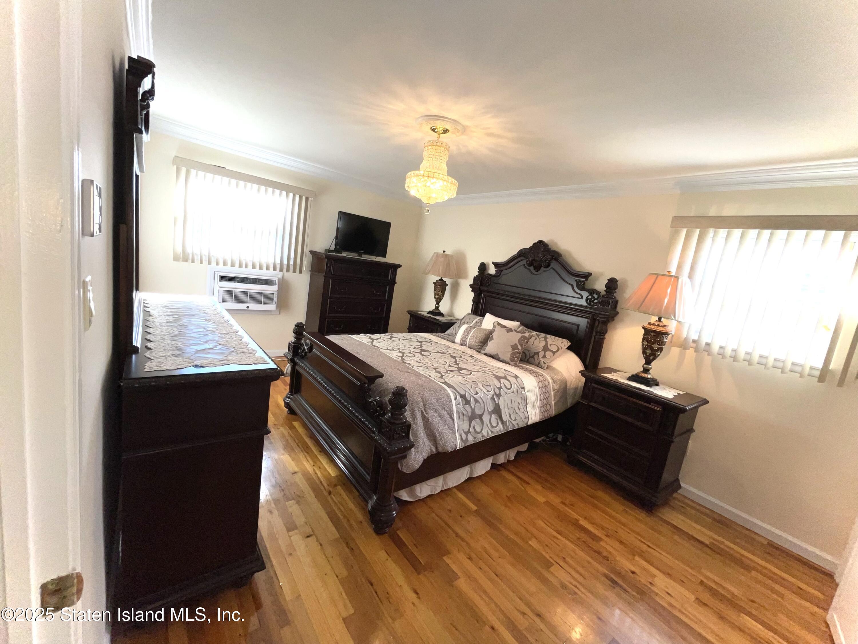 10 Token Street Staten Island, NY 10312 - Photo 27 of 39 a bed room with a bed and a chandelier