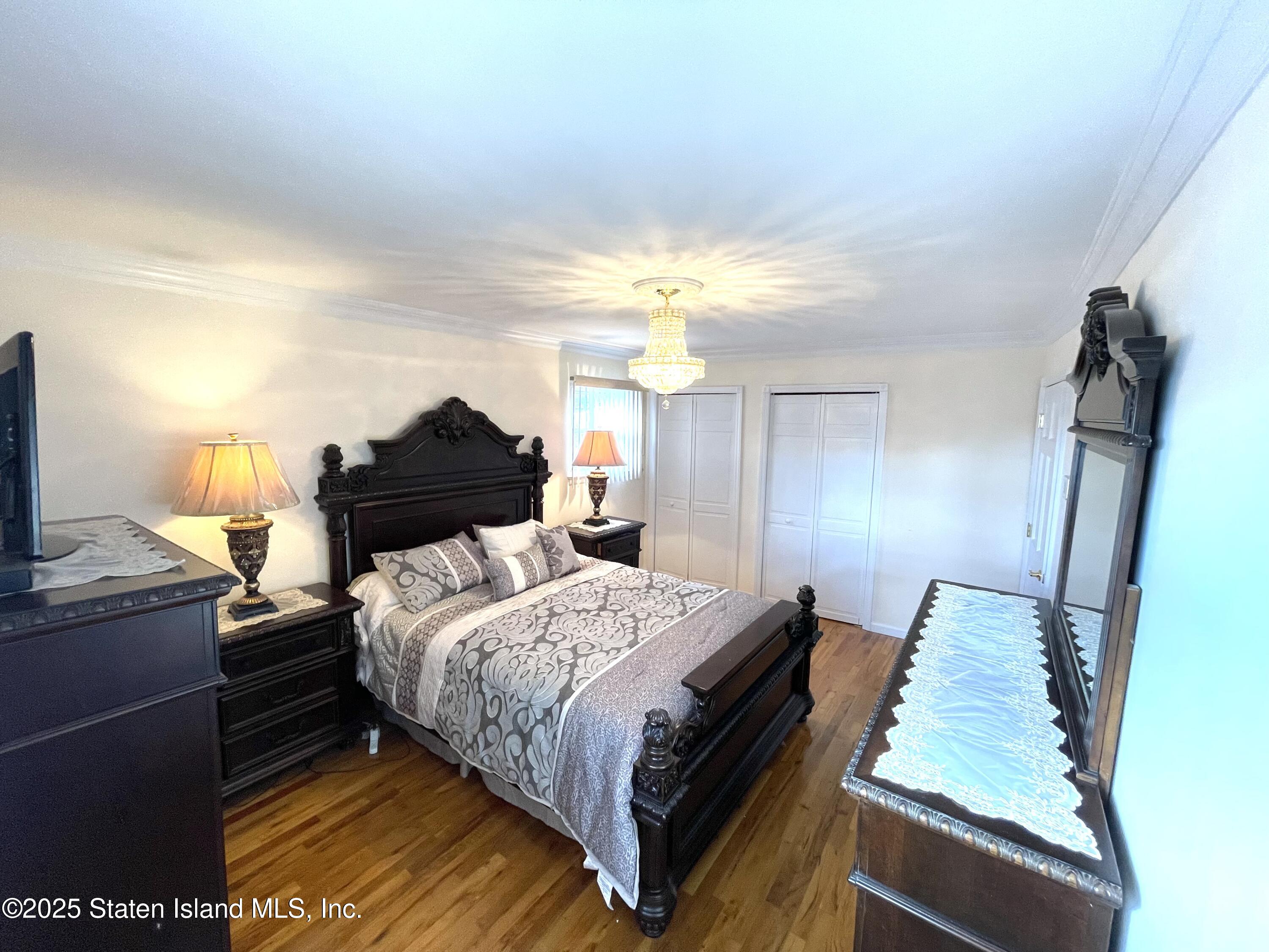 10 Token Street Staten Island, NY 10312 - Photo 29 of 39 a bedroom with a bed and a lamp with the dresser
