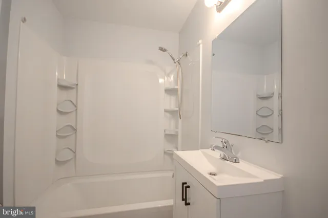 a bathroom with a sink mirror shower and a bathtub