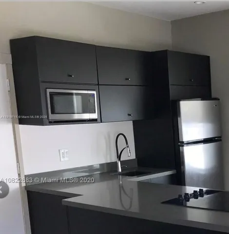 a kitchen with a sink and a refrigerator