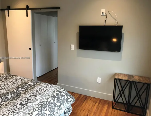 a bedroom with a bed and a flat screen tv