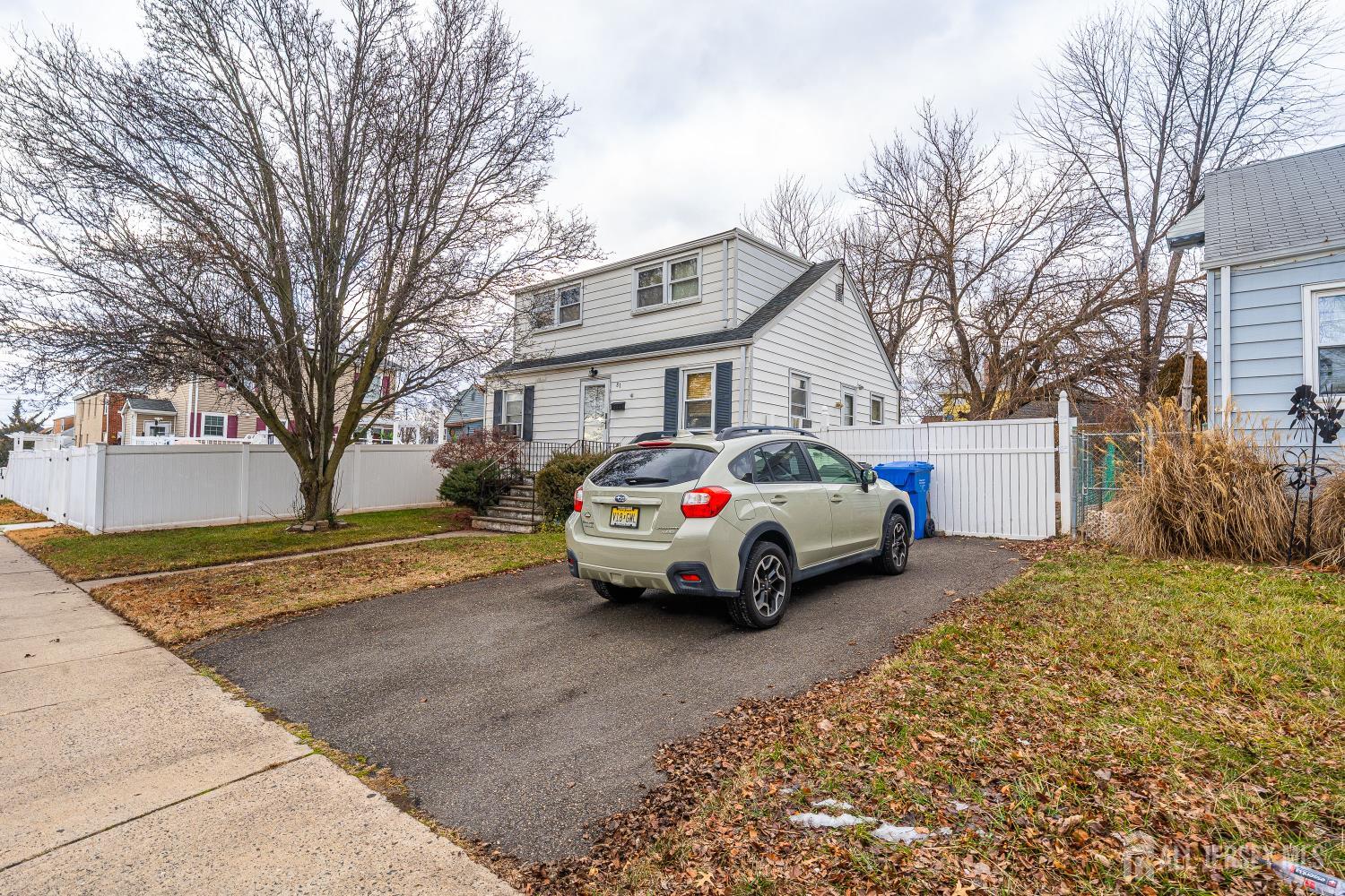 81 Larch Street Port Reading, NJ 07064 - Photo 15 of 25 a car parked in front of a white house