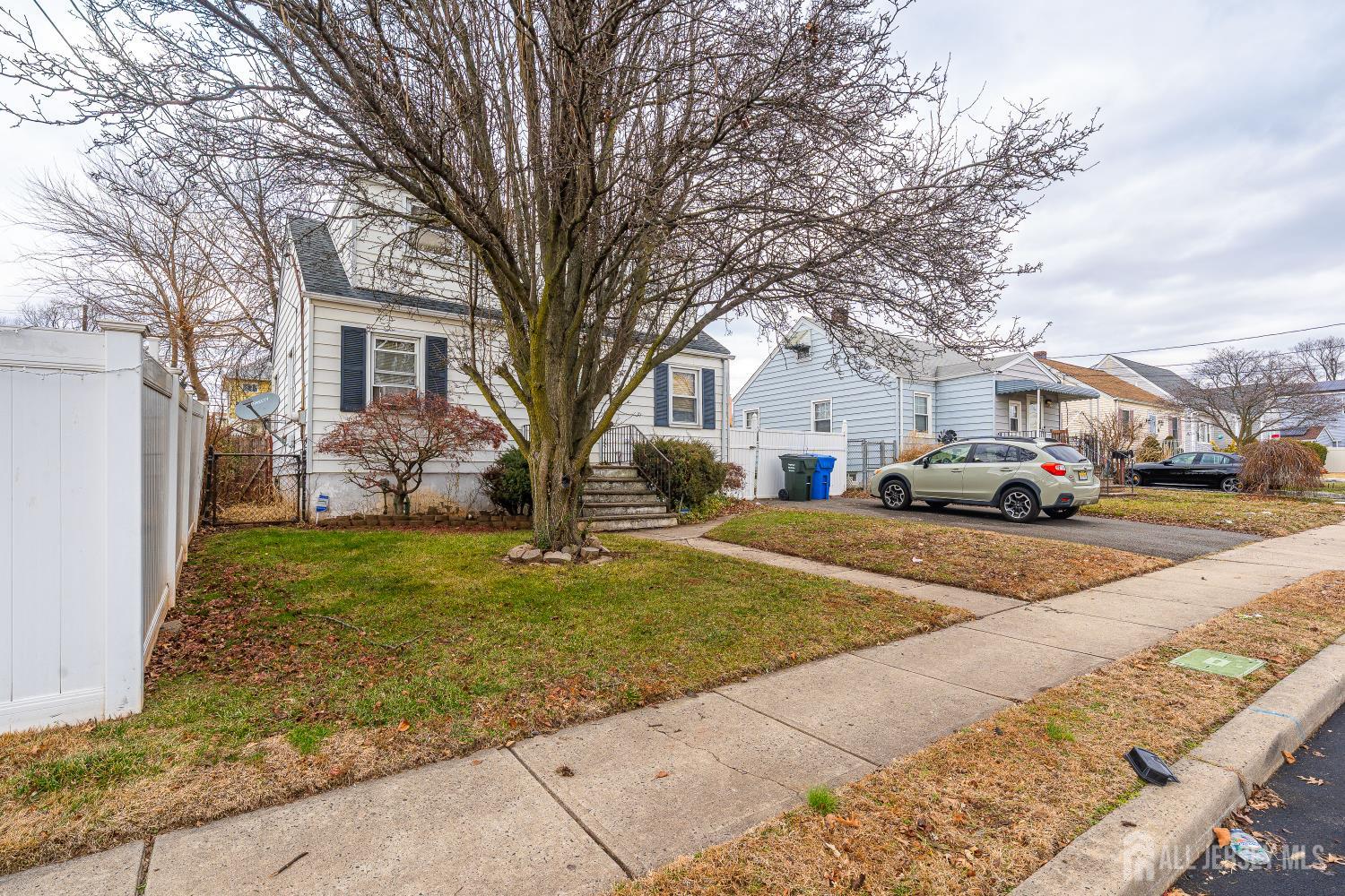 81 Larch Street Port Reading, NJ 07064 - Photo 16 of 25 a front view of a house with a yard and garage