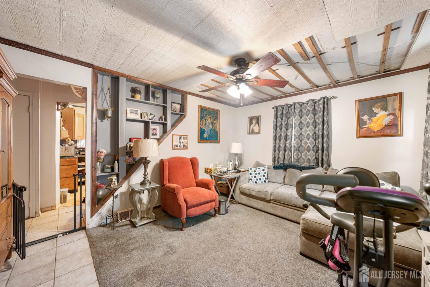 81 Larch Street Port Reading, NJ 07064 - Photo 2 of 25 a living room with furniture a ceiling fan and a window