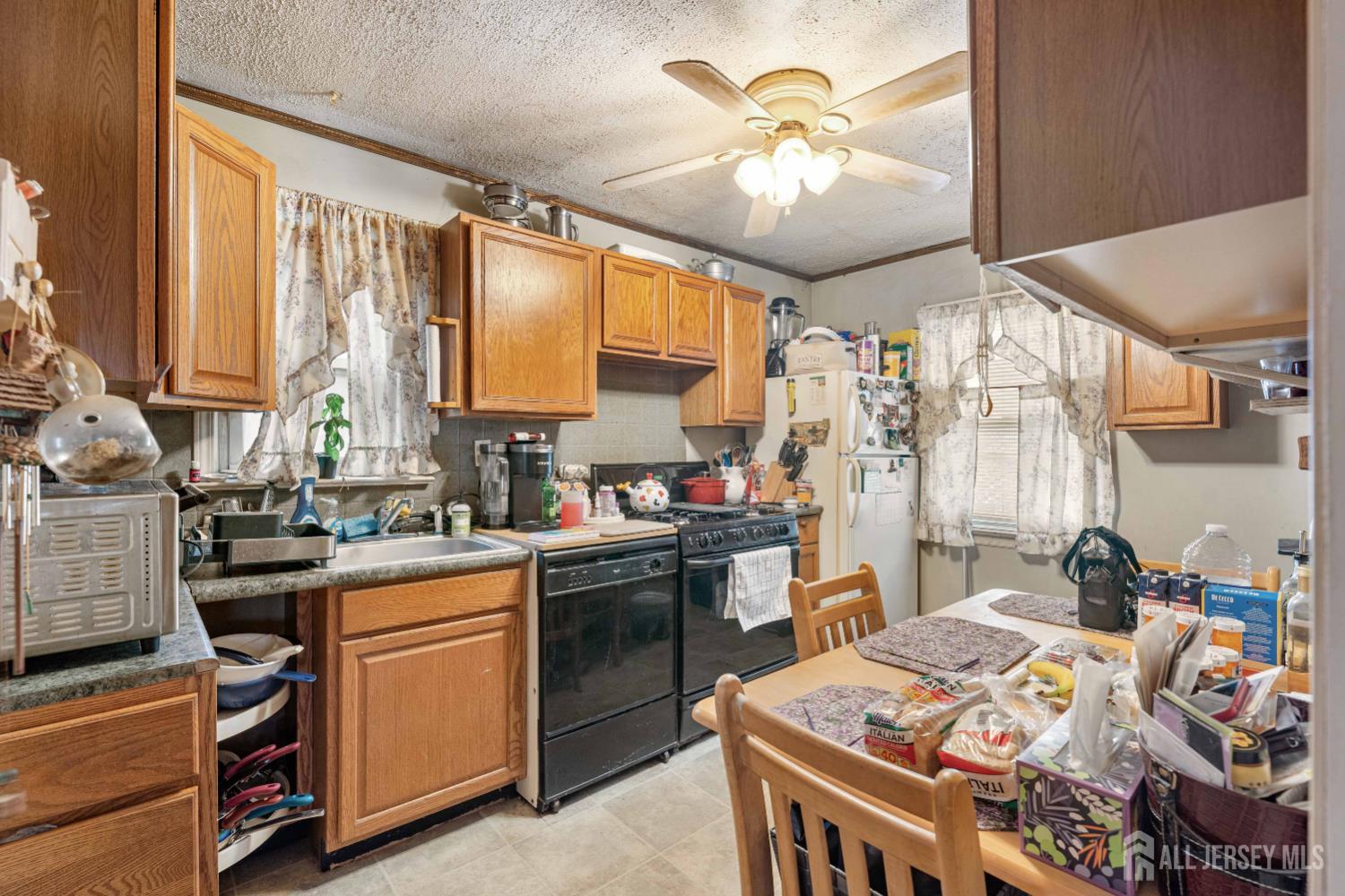 81 Larch Street Port Reading, NJ 07064 - Photo 5 of 25 a kitchen that has a lot of cabinets in it and a window