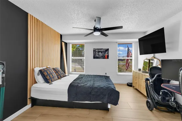 a spacious bedroom with a bed and a flat screen tv