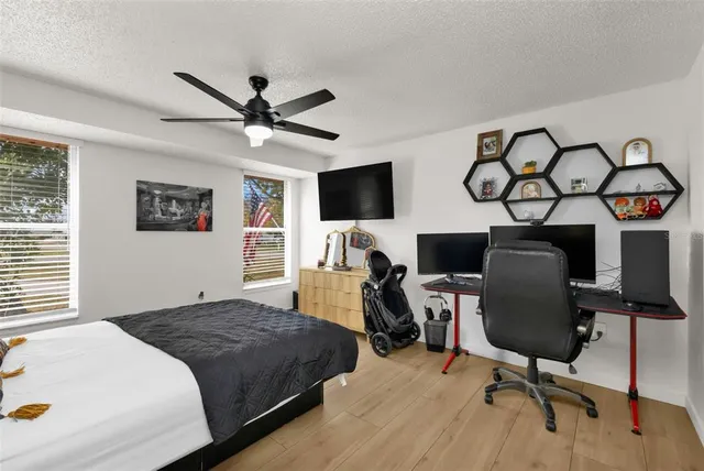a bedroom with a bed and a chair with the potted plant