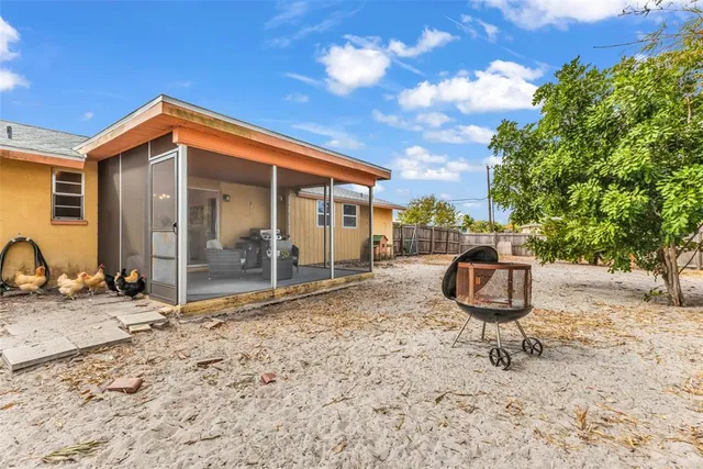 a backyard of a house with barbeque oven table and chairs
