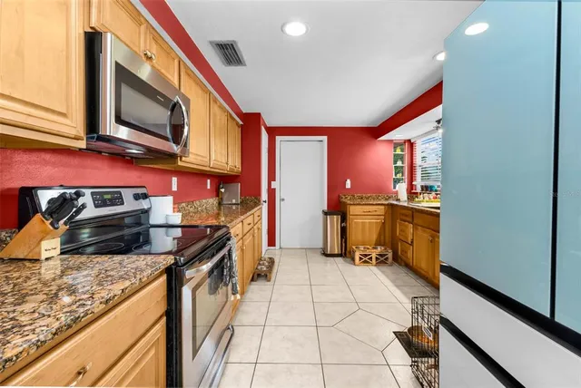 a kitchen with stainless steel appliances granite countertop a stove a sink and a microwave