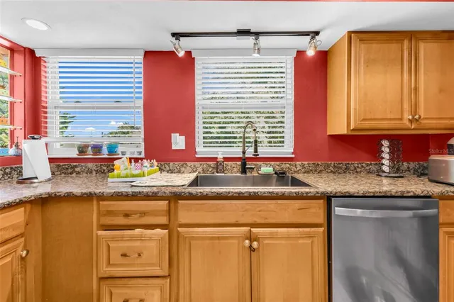 a kitchen with granite countertop cabinets and window