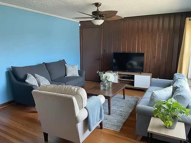 a living room with furniture a flat screen tv and a window