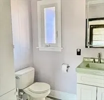 a bathroom with a toilet sink and mirror
