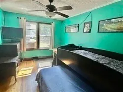 a bedroom with a bed window and a flat tv screen