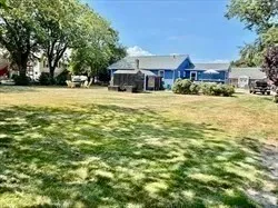 a front view of a house with a yard and trees