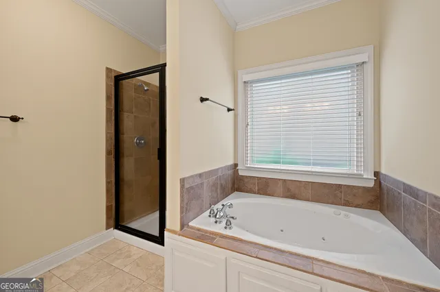 a bathroom with a tub a sink and a window