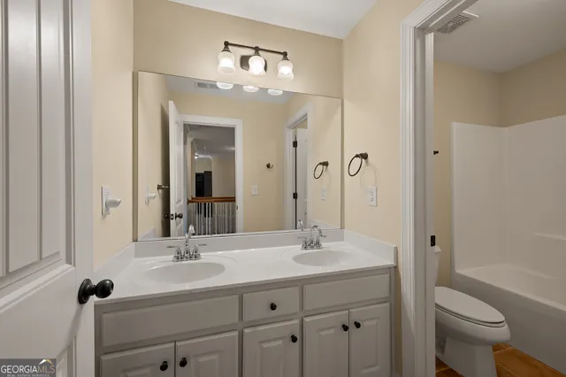 a bathroom with a sink toilet a mirror and shower