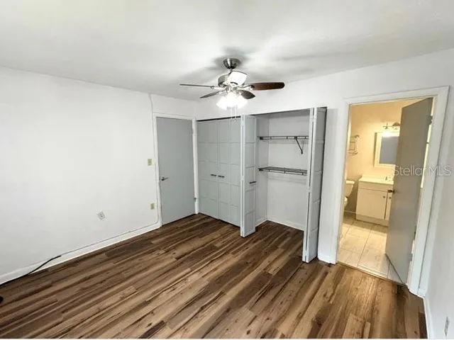 a view of a room with wooden floor and a ceiling fan