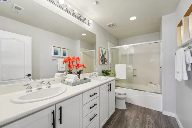 a bathroom with a double vanity sink mirror double and bathtub