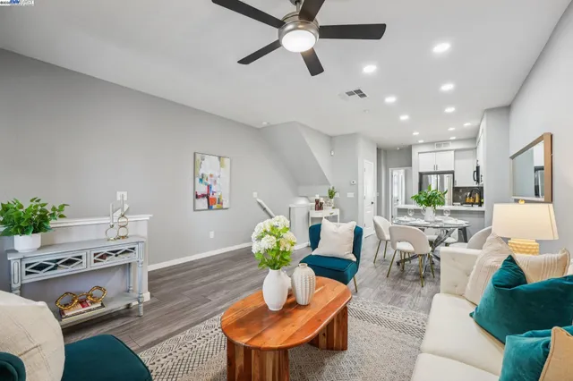 a living room with furniture kitchen view and a potted plant