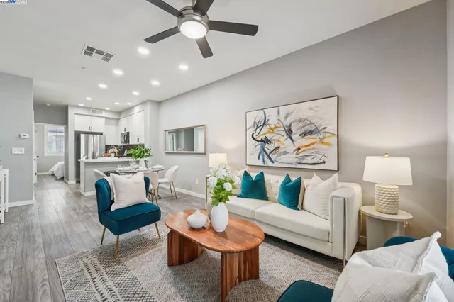 a living room with furniture and a view of kitchen