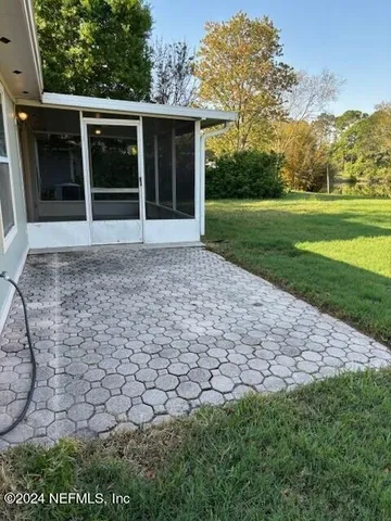 a view of a house with a yard and a large tree