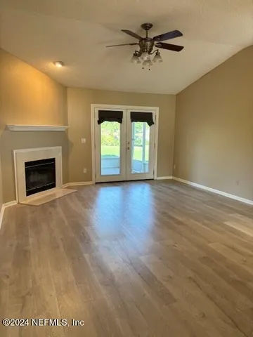 a view of an empty room with a fireplace and a window