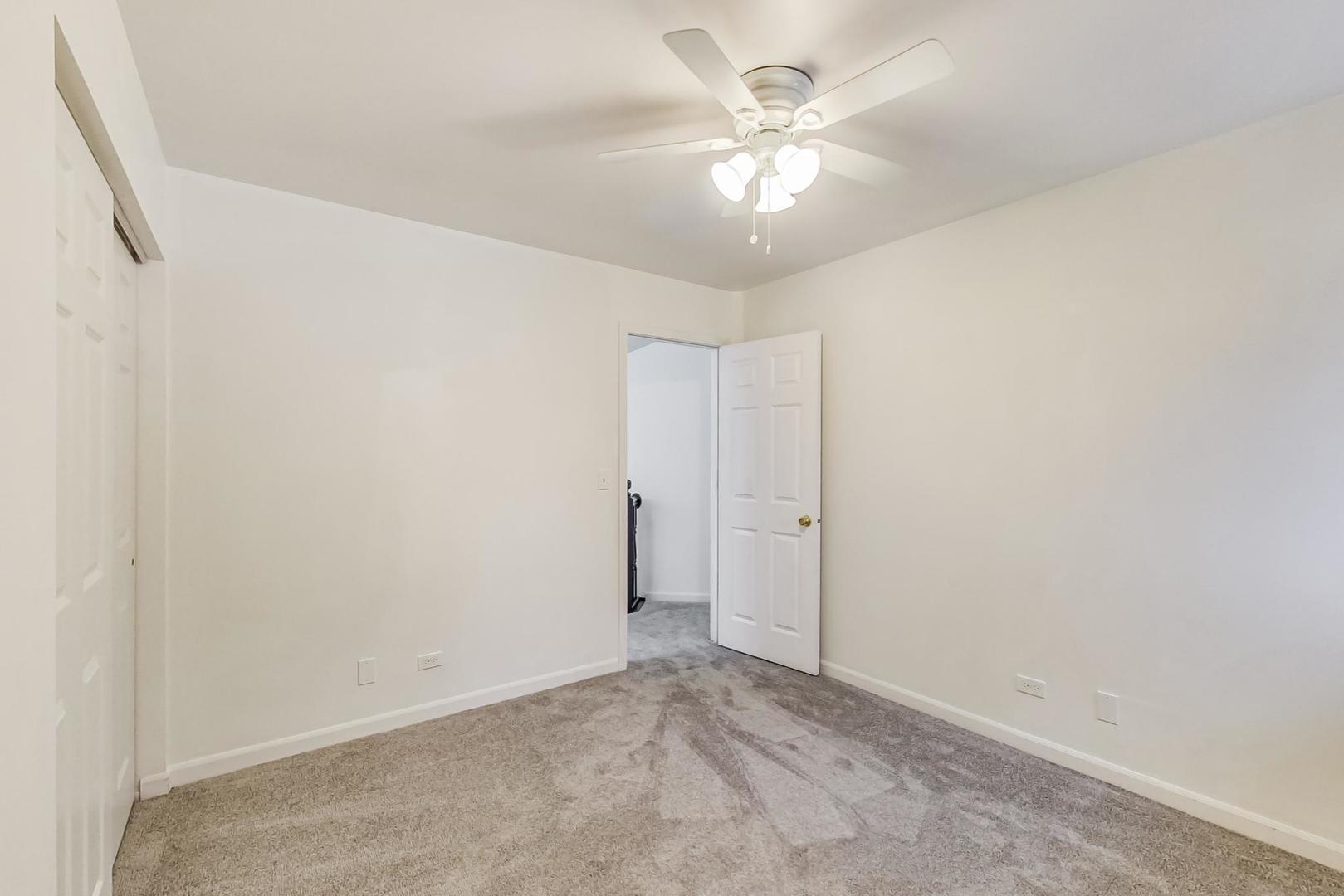 4000 Ridge Road Zion, IL 60099 - Photo 32 of 47 an empty room with a chandelier fan and view of bathroom