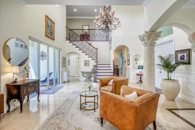 a living room with furniture a chandelier and a mirror