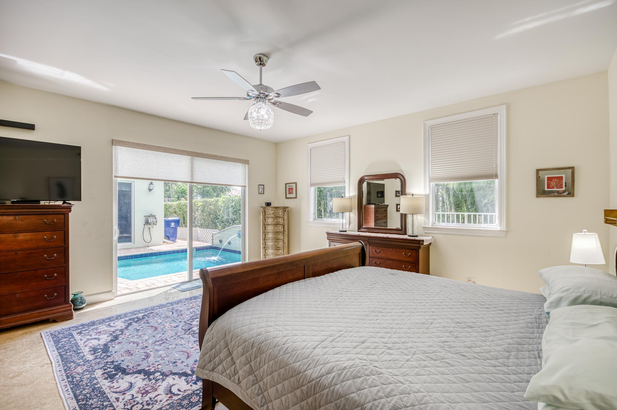 412 Meadowlark Drive Jupiter, FL 33458 - Photo 17 of 40 a bedroom with a large bed and a flat tv screen