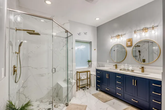 a bathroom with a double vanity sink mirror and shower