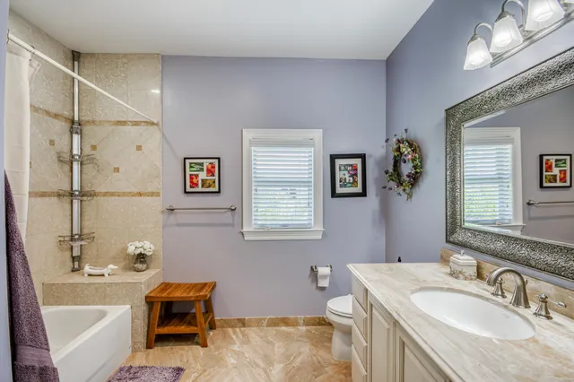 a bathroom with a tub sink and mirror