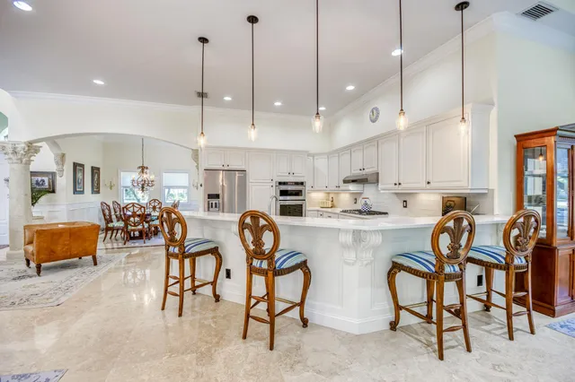 a kitchen with lots of white furniture and appliances